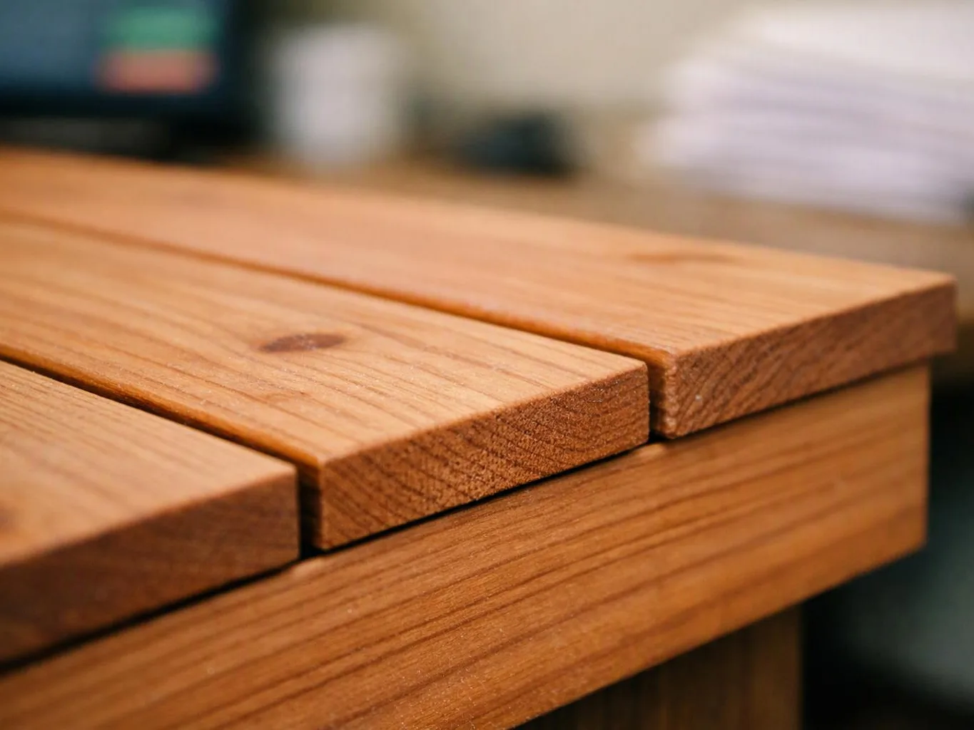 Close-up of wooden slats on a table, with a blurred indoor background